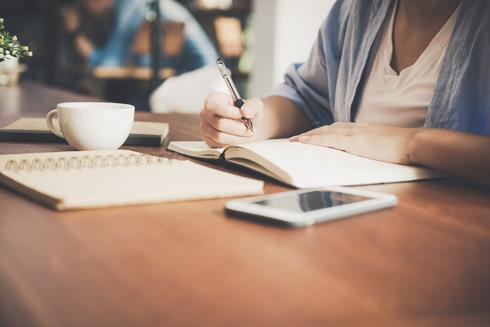 Woman with mobile phone and notebook - Photo by Tirachard Kumtanom on Pexels