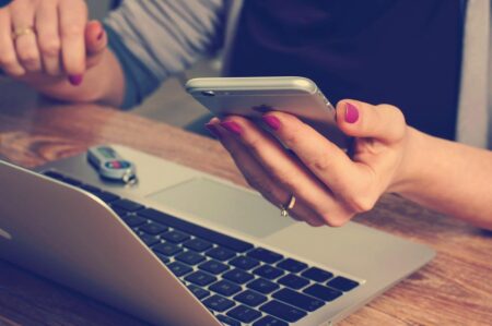 woman with phone and laptop